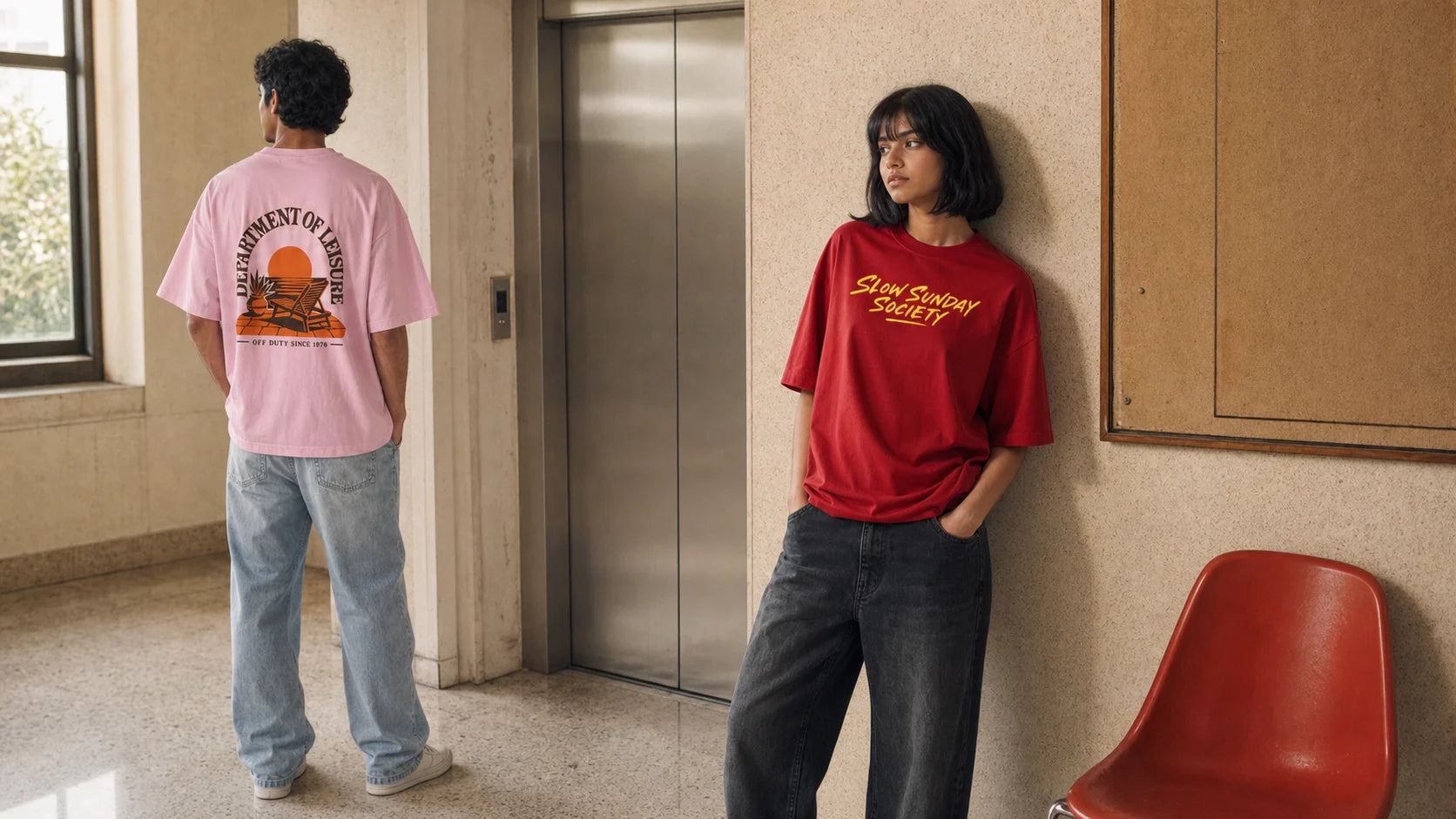 Two models wearing Made Loose oversized graphic tees while waiting by an apartment lift